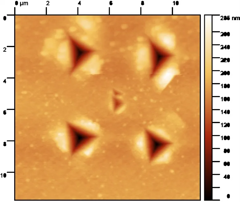 AFM topography of an array of nanoindents in electroplated copper, with a small additional indent placed in the centre.